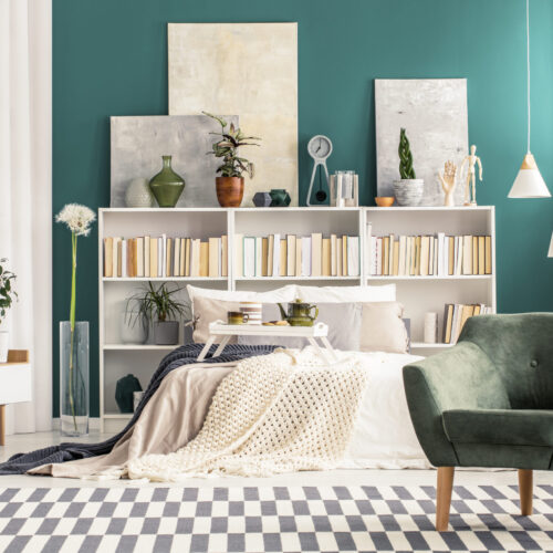 Cozy bedroom interior with white, scandinavian style furniture and turquoise green wall